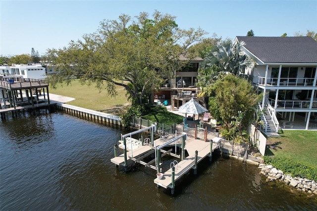 dock area with a lawn, a water view, and boat lift