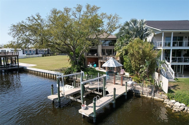 view of dock with a lawn, a water view, and boat lift