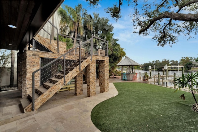 view of yard featuring stairway, a patio area, and a dock