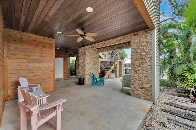 view of patio featuring ceiling fan and stairway