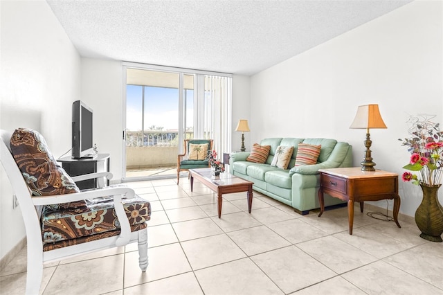 living room with floor to ceiling windows, a textured ceiling, and light tile patterned floors