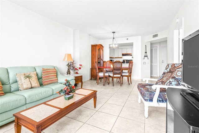 living area featuring light tile patterned floors, a textured ceiling, visible vents, and a notable chandelier