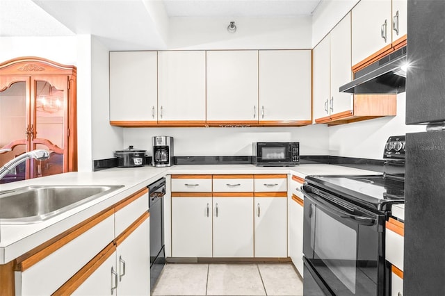 kitchen with under cabinet range hood, a sink, white cabinetry, light countertops, and black appliances