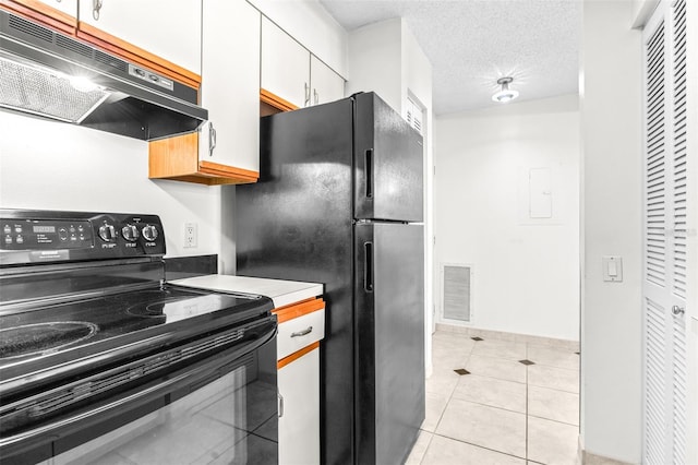 kitchen with light tile patterned floors, visible vents, under cabinet range hood, a textured ceiling, and black appliances