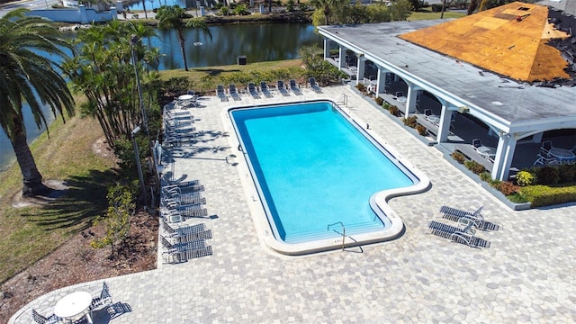 pool featuring a patio area and a water view