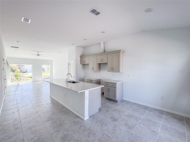 kitchen featuring visible vents, gray cabinetry, a ceiling fan, a sink, and baseboards