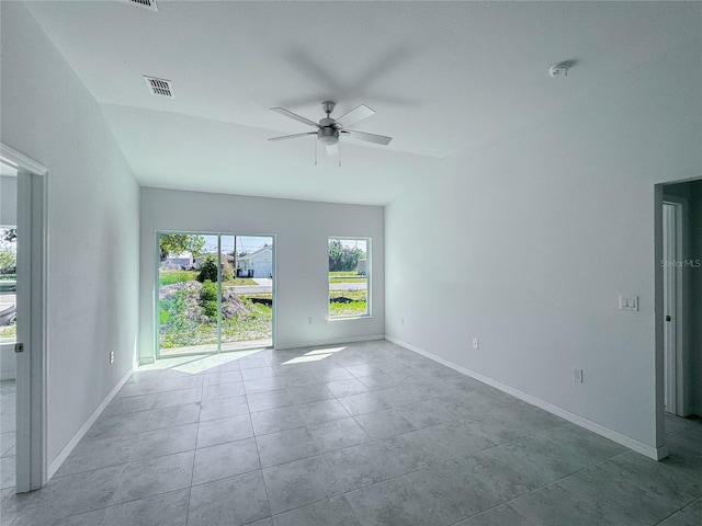 tiled empty room featuring visible vents, ceiling fan, and baseboards