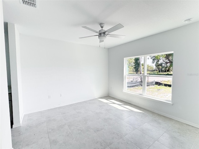 empty room featuring baseboards, visible vents, and a ceiling fan