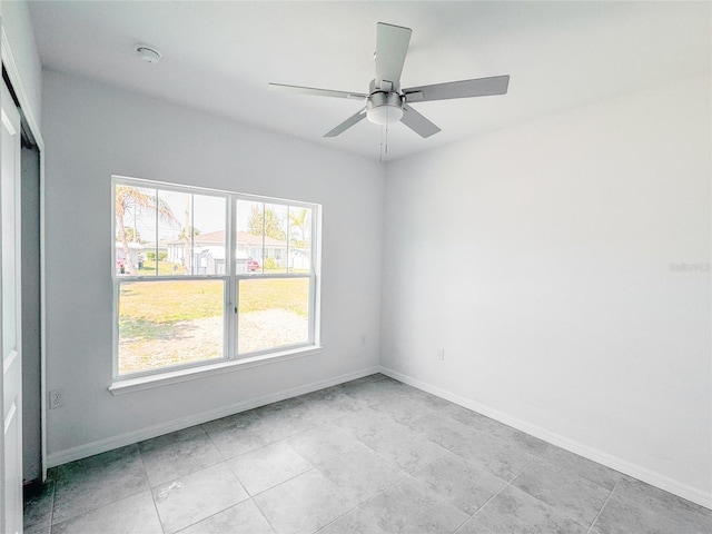 unfurnished room featuring ceiling fan and baseboards