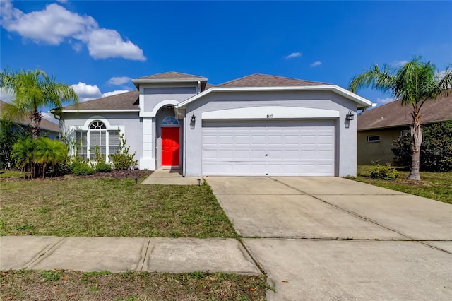 ranch-style home featuring a garage, driveway, a front yard, and stucco siding