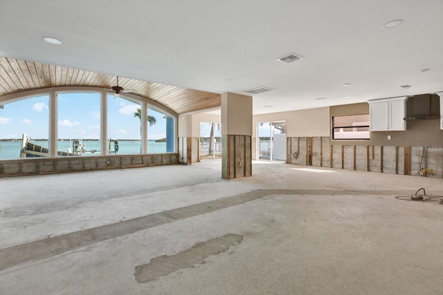 spare room with vaulted ceiling, a water view, and visible vents