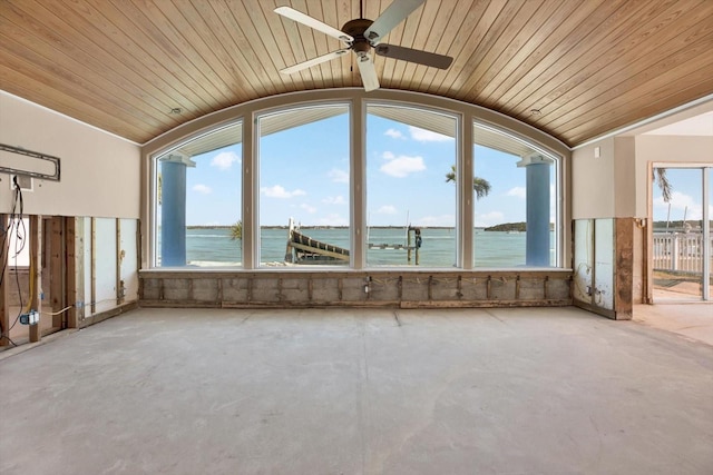 interior space with lofted ceiling, a water view, and unfinished concrete flooring