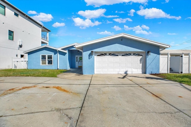 ranch-style house with a garage, driveway, fence, and stucco siding