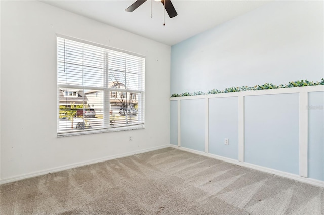 carpeted spare room featuring ceiling fan