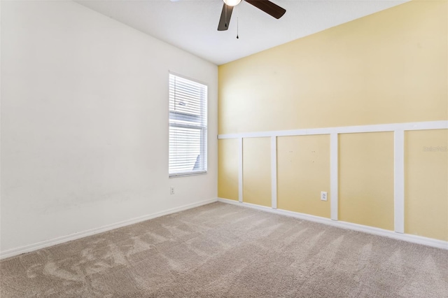 spare room featuring ceiling fan, carpet, and baseboards