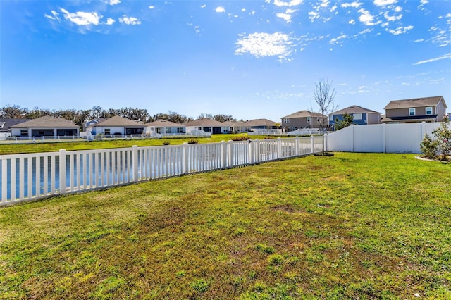 view of yard with a fenced backyard and a residential view