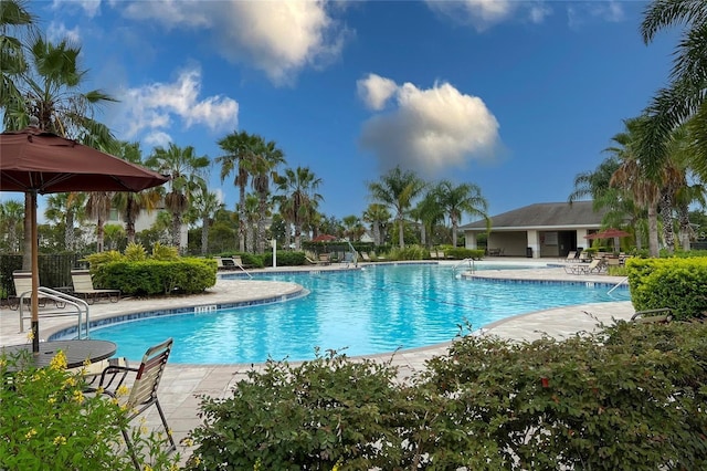 community pool with fence and a patio