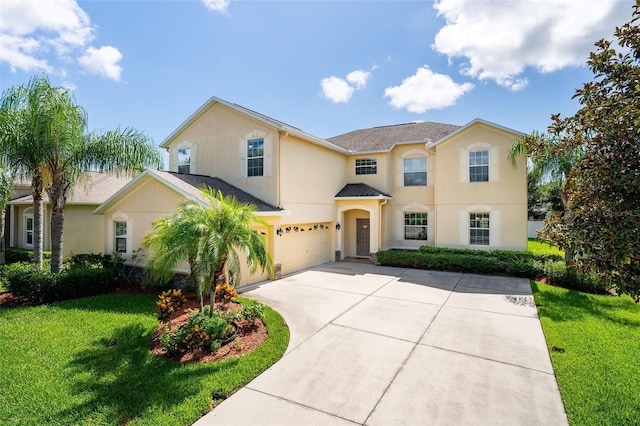 view of front of home with an attached garage, driveway, a front lawn, and stucco siding