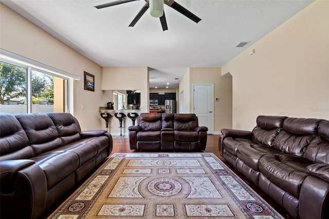 living room with visible vents, ceiling fan, a textured ceiling, and wood finished floors