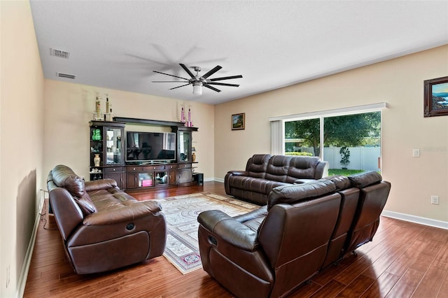 living room featuring ceiling fan, wood finished floors, visible vents, and baseboards