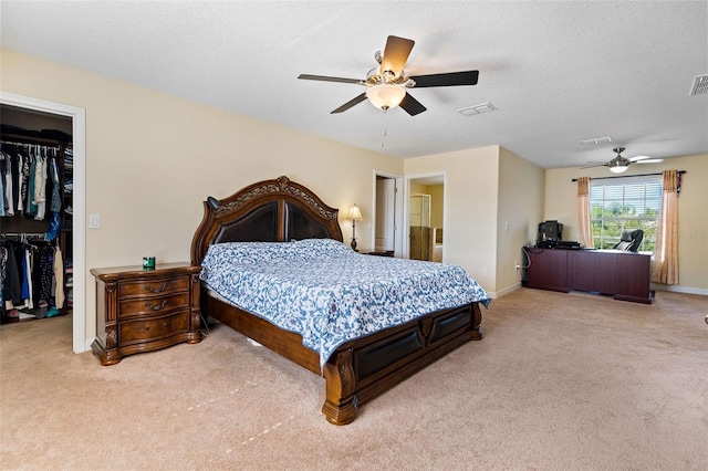 bedroom with a spacious closet, a closet, visible vents, and light colored carpet