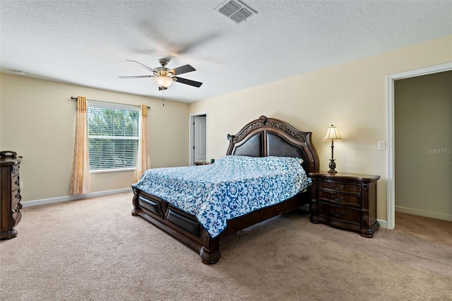 carpeted bedroom with a ceiling fan, visible vents, a textured ceiling, and baseboards