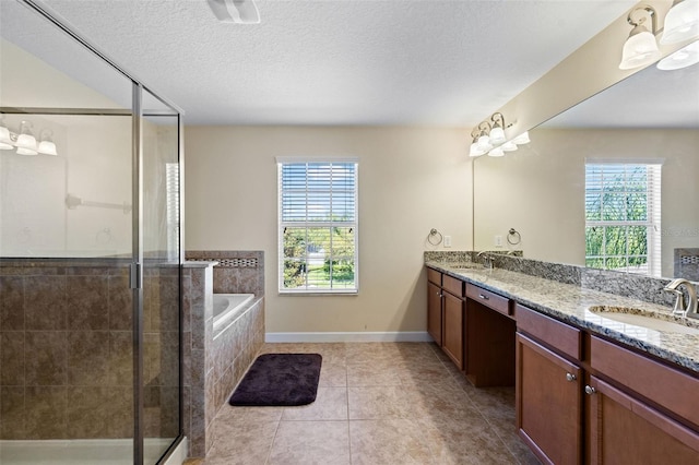 bathroom featuring double vanity, a stall shower, and a sink