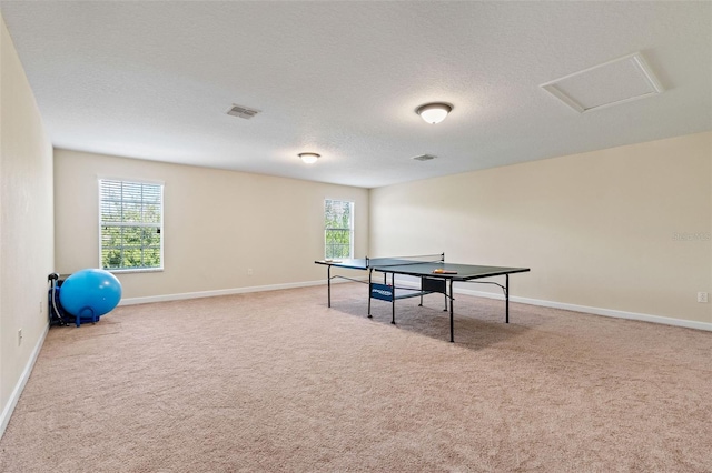 rec room featuring a wealth of natural light, attic access, a textured ceiling, and carpet flooring