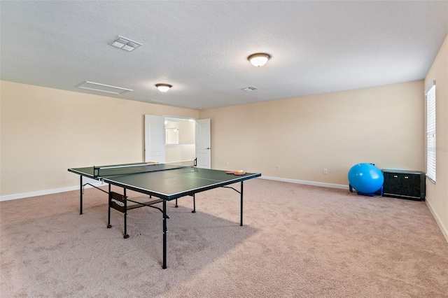 playroom with baseboards, a textured ceiling, visible vents, and carpet flooring