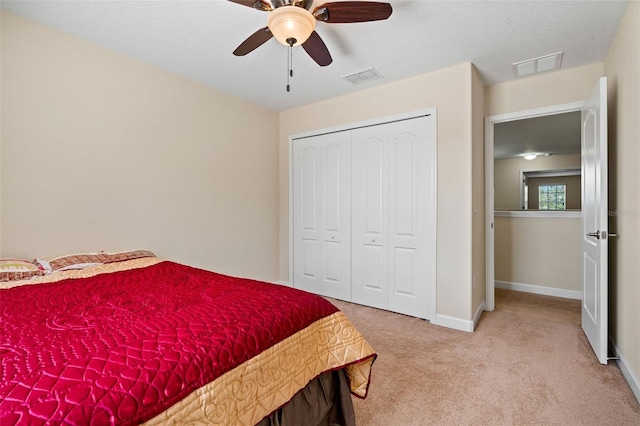 carpeted bedroom featuring a ceiling fan, a closet, visible vents, and baseboards