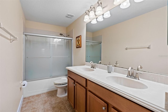 full bath with toilet, double vanity, a sink, and visible vents