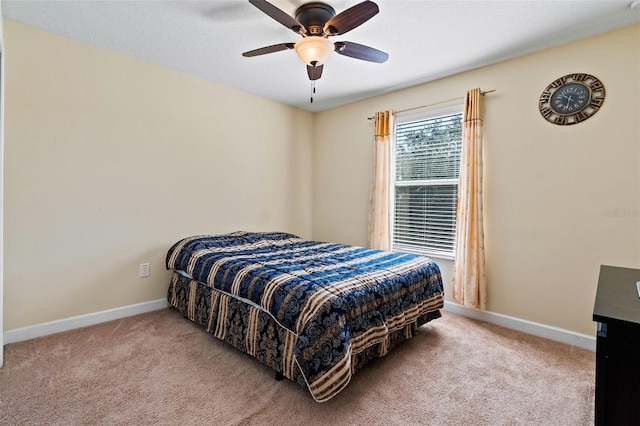 carpeted bedroom with a ceiling fan and baseboards