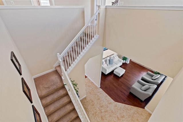 stairway with wood finished floors and baseboards