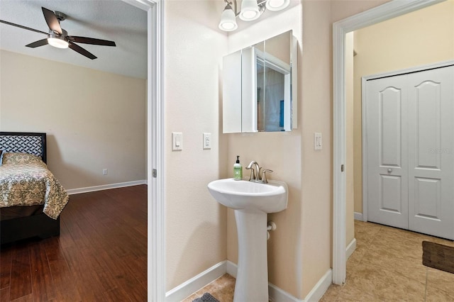 bathroom with a sink, baseboards, a ceiling fan, and wood finished floors