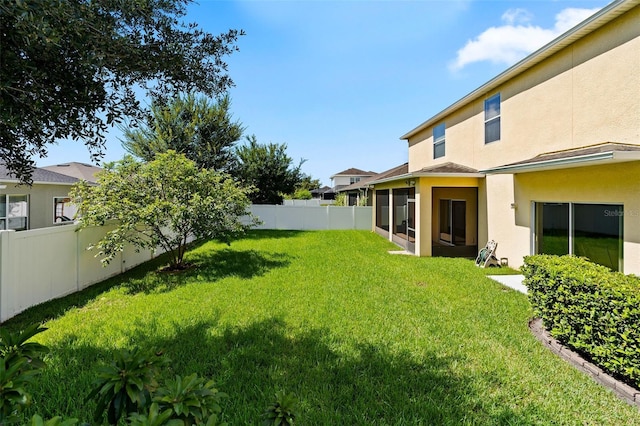 view of yard featuring a fenced backyard and a sunroom