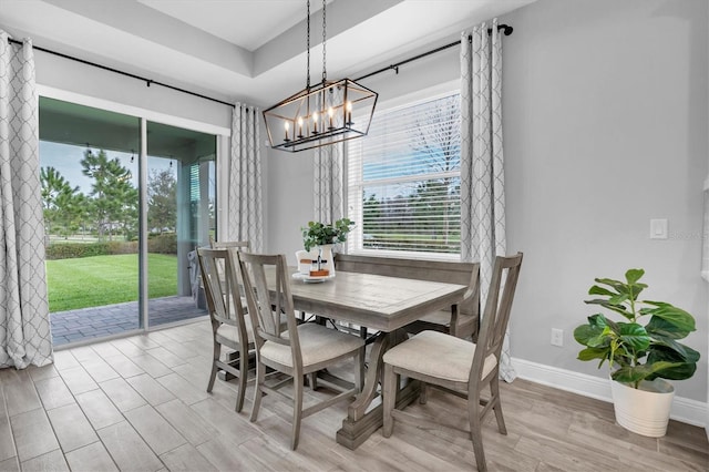 dining area with light wood-type flooring and baseboards