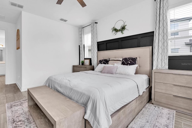 bedroom with visible vents, baseboards, and wood finished floors