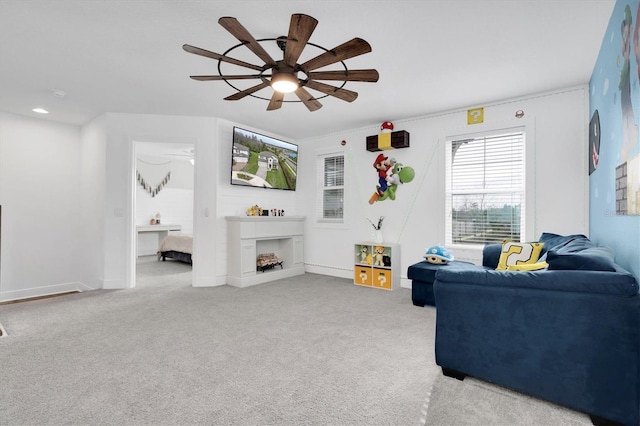 living room featuring carpet floors, a fireplace, baseboards, and a ceiling fan