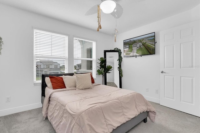 carpeted bedroom featuring baseboards and a ceiling fan