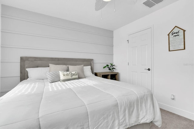 carpeted bedroom featuring a ceiling fan, visible vents, and baseboards