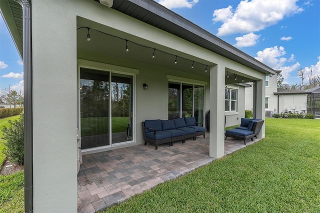 rear view of house featuring a patio, a yard, outdoor lounge area, and stucco siding