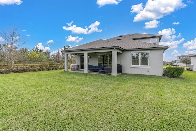 back of house with roof with shingles, a yard, a patio, stucco siding, and an outdoor living space