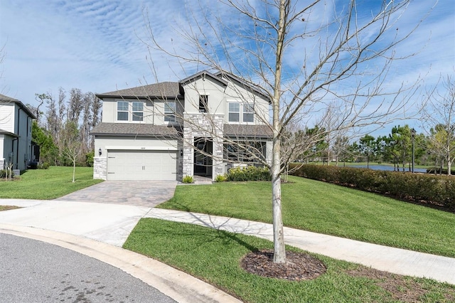 view of front of house featuring decorative driveway, stucco siding, an attached garage, stone siding, and a front lawn