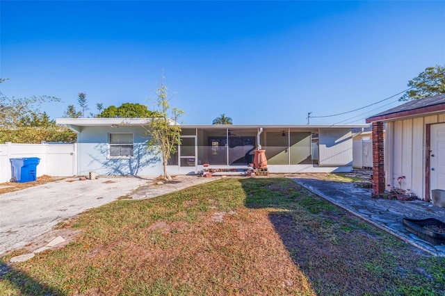 view of front of property featuring a front lawn, fence, and a sunroom