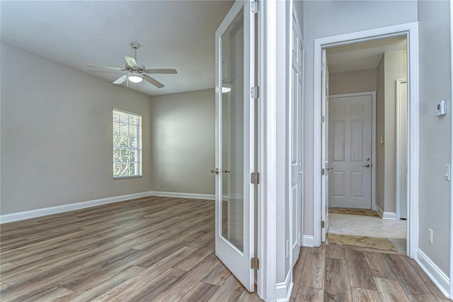 corridor featuring light wood-style flooring and baseboards