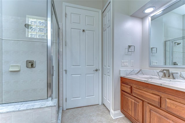 full bathroom with a stall shower, vanity, and tile patterned floors