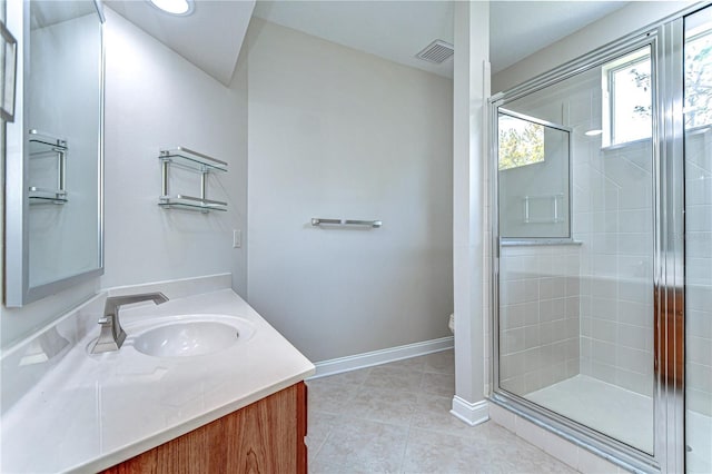 bathroom featuring tile patterned flooring, vanity, visible vents, baseboards, and a shower stall