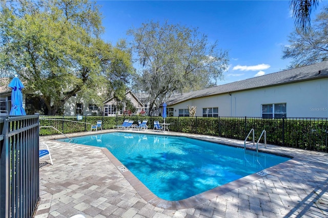 pool with a patio area and fence