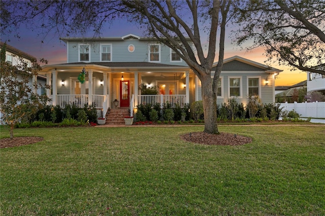 view of front of property with a yard, a porch, and fence