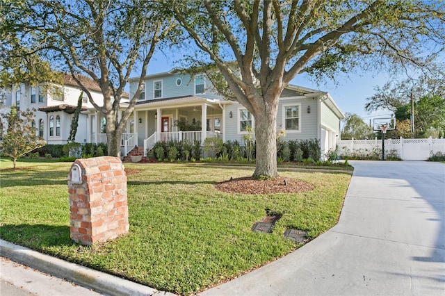 view of front of house with covered porch, fence, driveway, and a front lawn